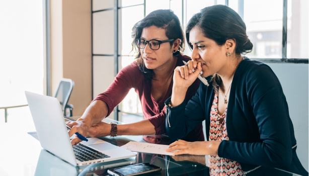 Two women discussing something on a laptop