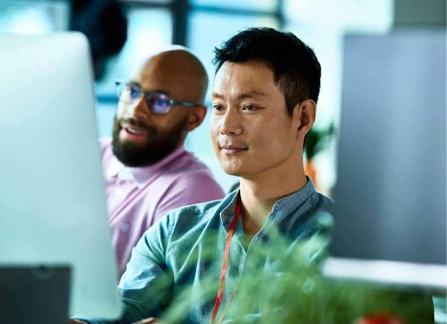 Two people working with a desktop PC
